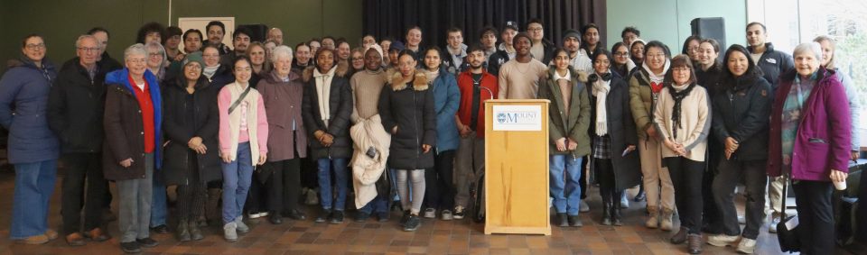 Mount Saint Vincent University's Business and Tourism students who volunteered for the department Caritas Day opportunities are standing all together for a group photo inside of the pub before they went out in the community. They all look pretty excited to be doing this.