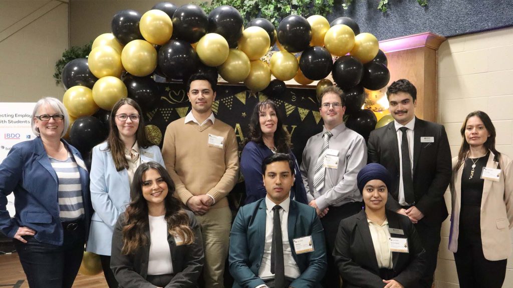 Business and Tourism society posing in front of the the 50th anniversary black and gold balloon display at the Learners and Leaders conference 2025.