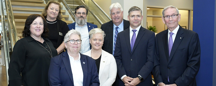 Dr. Joël Dickinson, alongside several executives from Shannex, posing in front of the stairs at the Shannex head office