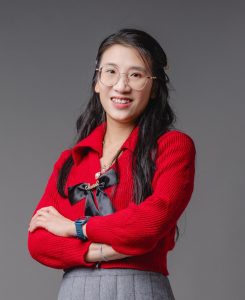 Winny (Wei) Liang - posing with her arms crossed in a red shirt