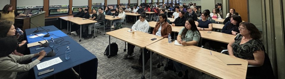 Business and Tourism career week Fall 2024. Photo of panelists and students while the panel session is in full swing. Shot from the corner of the room with a wide angle.