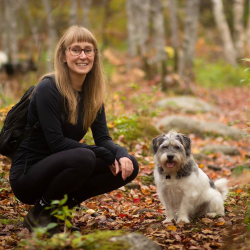 Dr, Catherine Reeve and her dog Walker posing outside in the forest