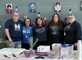 Several Co-op Office staff members celebrating the 45th anniversary with a cake and prizes