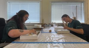 Alyssa Rose helping another student, Emily, sort Moths in a display