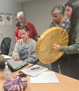 Participants in the Two Eyed Seeing program look at a laptop togther