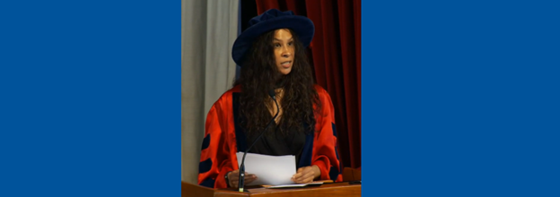 El Jones, speaking at Acadia University, surrounded by two blue squares