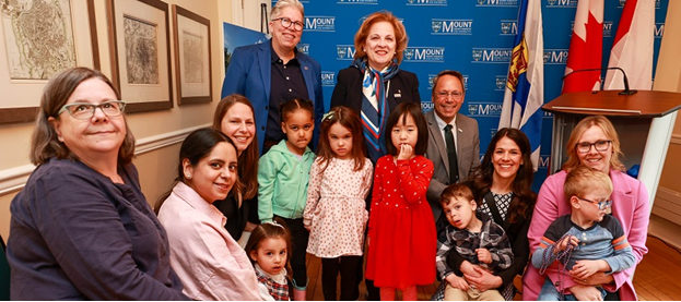 Children from the Child Study Centre standing alongside Government officials in a group photo