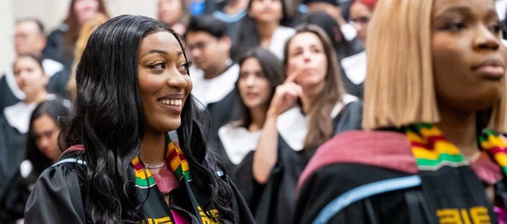 A student wearing a Kente stole smiling at a MSVU convocation ceremony