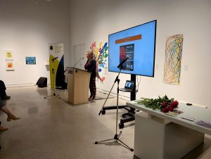 A staff member from the Alexa McDonough Institute for Women, Gender and Social Justice speaking at a podium