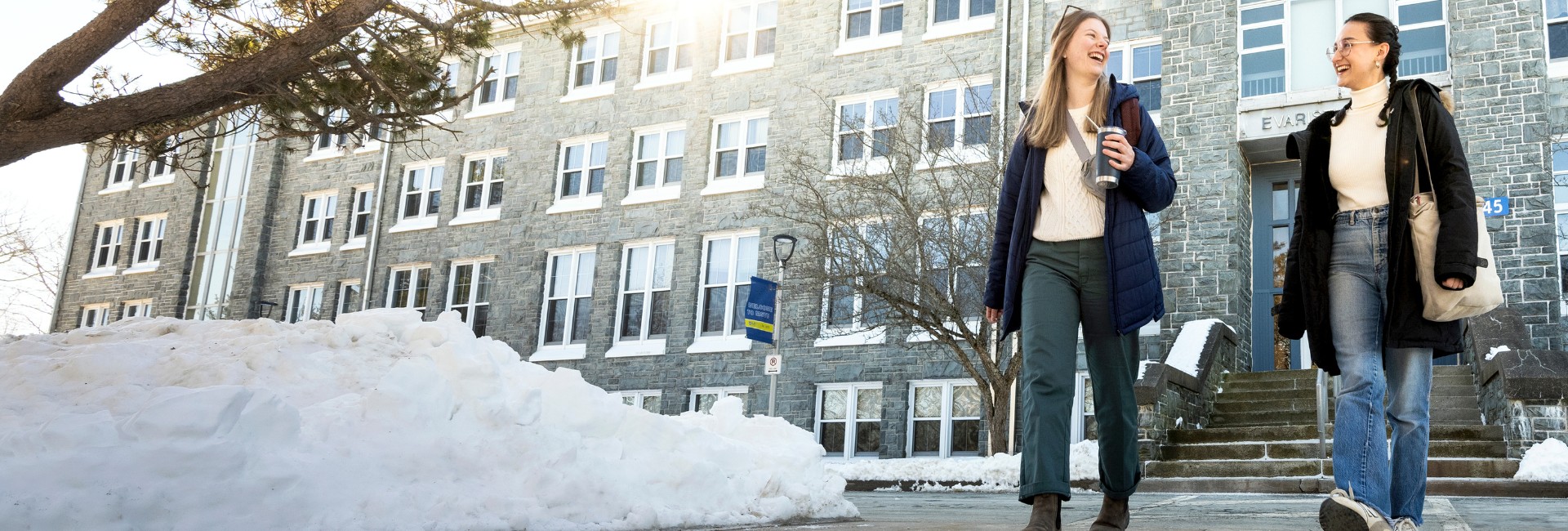 Two students walking in front of the Evaristus building