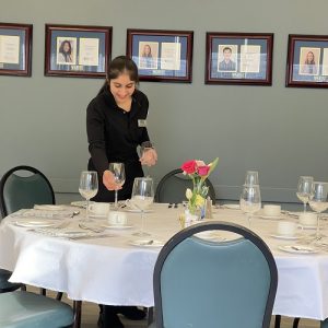 A Student setting up the table for Vincent's restaurant